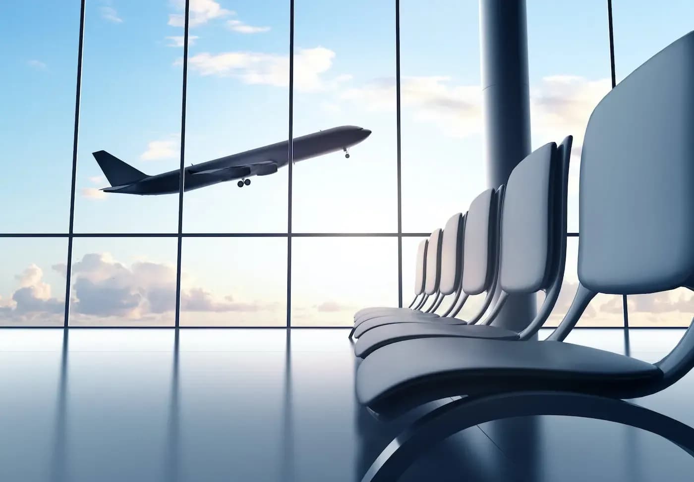 Asientos vacíos en una sala de espera de aeropuerto, con un avión despegando visible a través de grandes ventanales