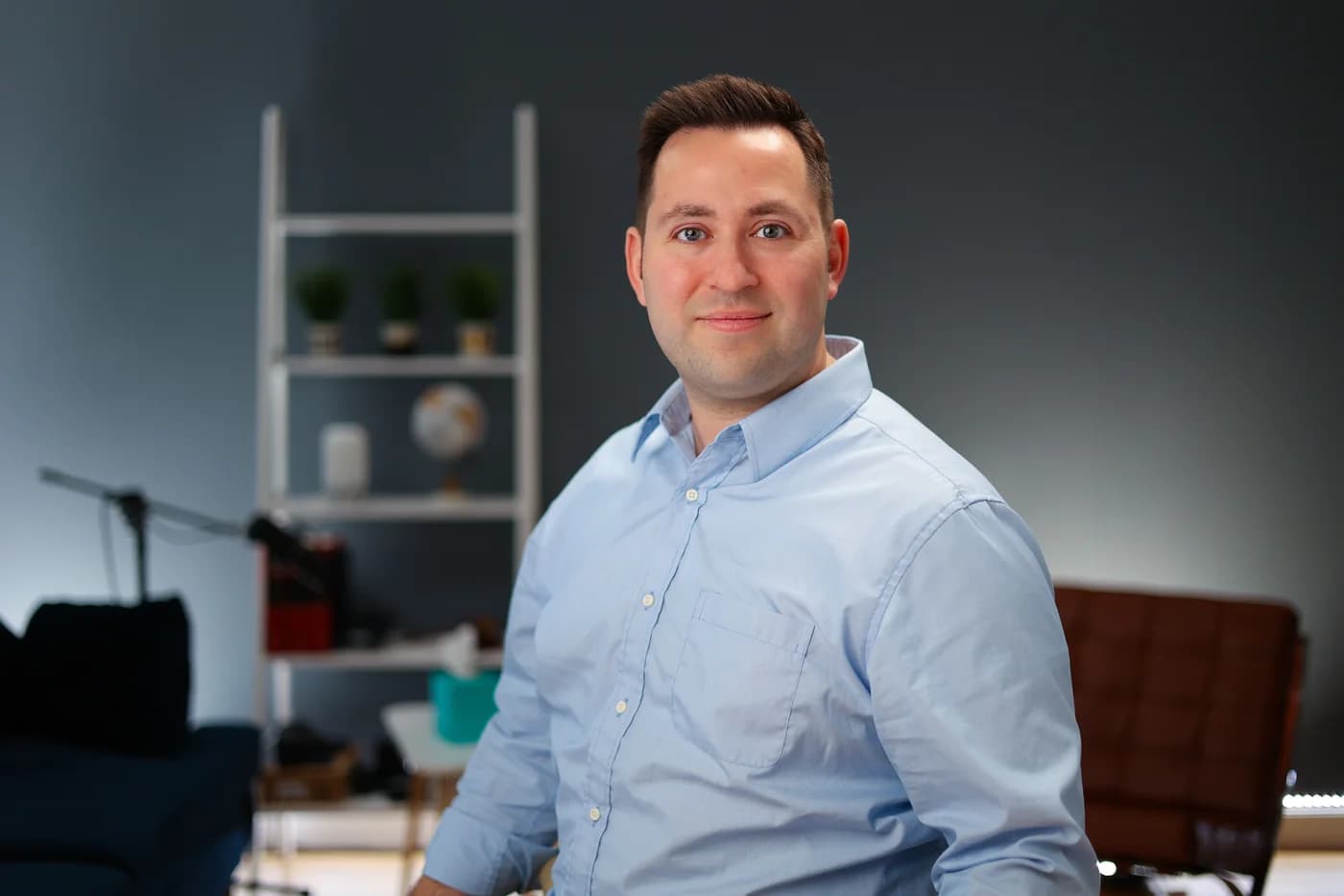 Male attorney in light blue button-up shirt posing in modern office setting