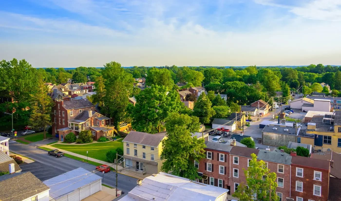 Aerial view of a small town with brick buildings and tree-lined streets